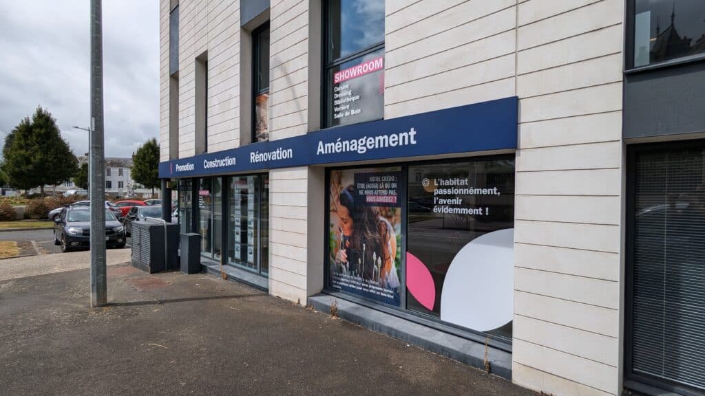 Façade d’une agence Alliance mettant en avant ses services de promotion, construction, rénovation et aménagement, avec des vitrines modernes, un showroom signalé et un emplacement en centre urbain accessible.