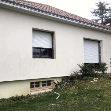 Travaux d'enduit en cours sur une façade extérieure d'une maison individuelle, préparation des contours des ouvertures pour une finition soignée. Projet de rénovation extérieure en cours.